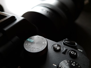A photo camera with the mode selector wheel on top for shutter, aperture and manual control (pasm).