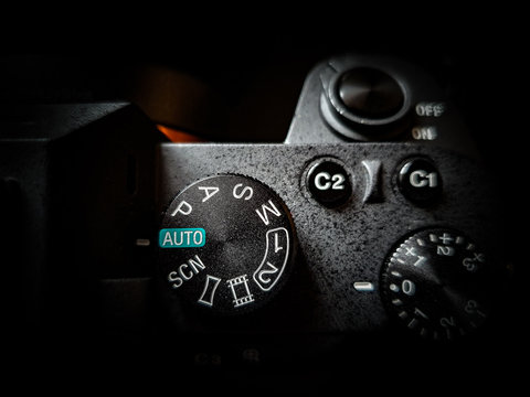 A photo camera with the mode selector wheel on top for shutter, aperture and manual control (pasm).