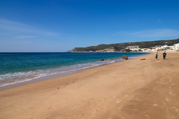 Fototapeta na wymiar beach with people walking in the background