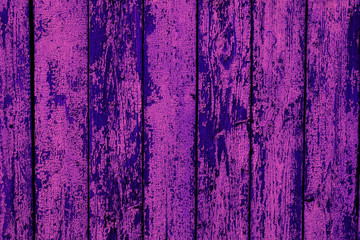 the old fence is a fragment of pink color, the paint peels off from the wooden surface
