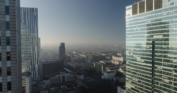 Drone footage in between skyscrapers and glass office buildings in Warsaw city center.