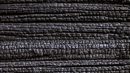 Black burnt charred wooden wall. Grungy texture