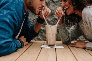 Loving couple sharing milkshake - Powered by Adobe