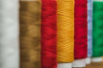 selective focus of colorful cotton thread coils in row with copy space