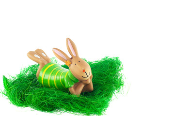 hare in a green striped dress in the yellow lies on the green grass on a white background side view