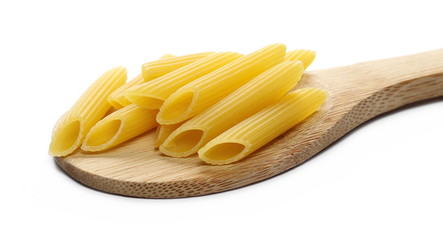 Penne rigate pasta pile with wooden spoon isolated on white background