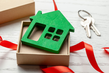 Gift box with red ribbon and house with keys. House as a gift