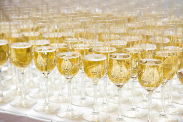 A row of glasses filled with champagne are lined up ready to be served. Coffee break prepare for serve guests attending seminar.break time in meeting room