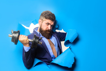 Through paper. Bearded man with dumbbell. Sport. Bearded man through paper. Copy space for advertising. Workout. Fitness. Healthy lifestyle. Discount, sale, season sales.