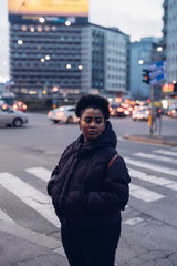 young black and curly girl posing in the street