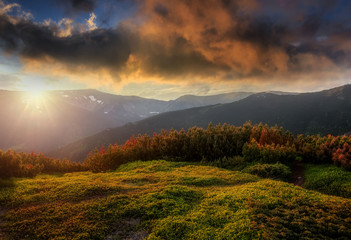 Awesome alpine highlands in sunset. Colorful Sky under sunlight over the high mountain.