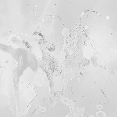 Silver, gray wet abstract paint leaks and splashes texture on white watercolor paper background. Natural organic shapes and design.
