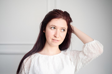 portrait of young caucasian woman with red hair in white shirt on white background