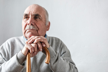 Grey haired elderly man with mustache thinking