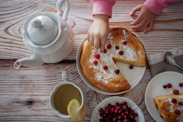 Children breakfast with Cheesecake with cranberries and sugar on wooden table