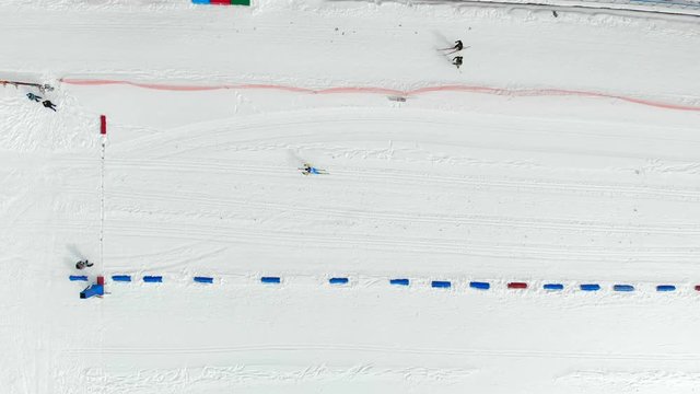 Aerial view on top. Skier athlete overcomes the distance in biathlon, and arrives at the finish