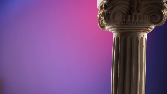Single ancient corinthian column rotating slowly on color background