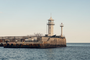 Fototapeta na wymiar Lighthouse on Yalta embankment, Crimean resort on Black Sea
