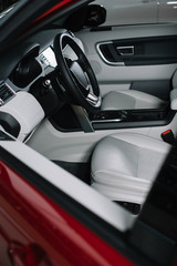 Fototapeta na wymiar black steering wheel and grey seats in red automobile