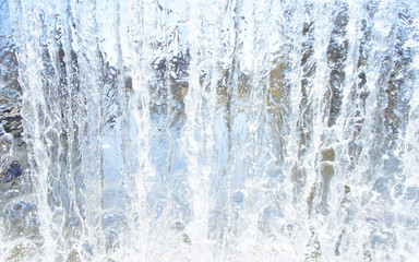 Naklejka na ściany i meble Transparent blue white water pours from above. View through the water wall of the waterfall for the background.
