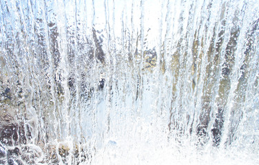 Plakat Transparent blue white water pours from above. View through the water wall of the waterfall for the background.