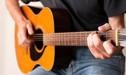 Fototapeta na wymiar Man finger picking a C chord whilst playing an Acoustic Guitar