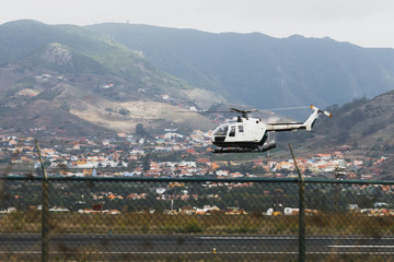 police aviation helicopter above the airstrip, mountain background