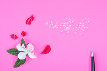 concept of a greeting postcard with a some flowers and a pen, with space for text, top view flatlay. Wedding day text