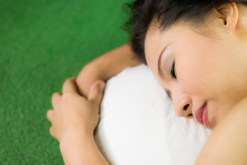 women sleep on the green grass, a beautiful and dreamy Thai woman laying down on green grass, relaxing