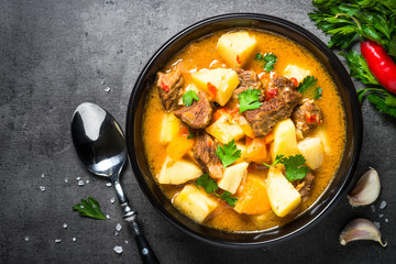 Beef stew with vegetables - carrot, ppototo and pumpkin on black