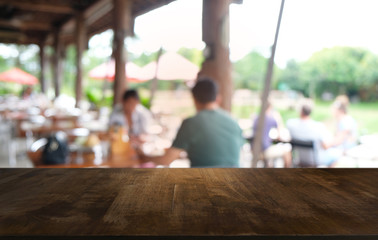 Empty dark wooden table in front of abstract blurred bokeh background of restaurant . can be used for display or montage your products.Mock up for space.