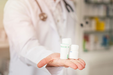 Male doctor holding in hand various drug boxes