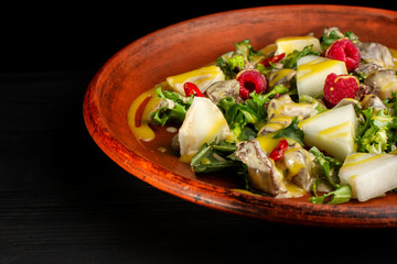 Raspberry, pineapple, lettuce and champignon salad with sauce.