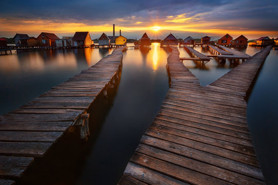 Sunset over lake Bokod with wooden pier and floating houses, Hungary