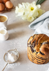 Modern pastries vanilla and chocolate cruffin whole and slice like croissant and muffin with powder sugar served with a cup of coffee.