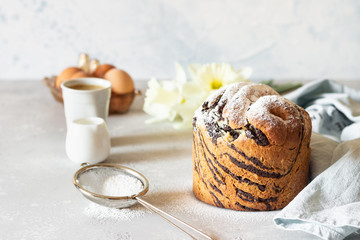 Modern pastries vanilla and chocolate cruffin whole and slice like croissant and muffin with powder sugar served with a cup of coffee.