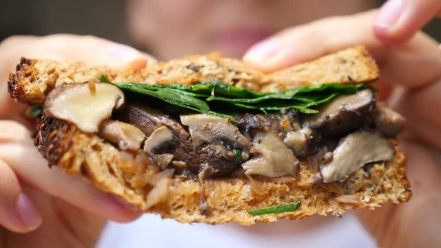 Female Hands Holding Vegan Mushroom Sandwich. Closeup.