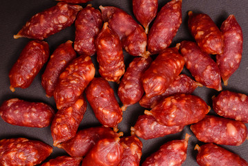 Snack to beer. Small sausages to frothy drink. Background of sausages on a dark background close-up.