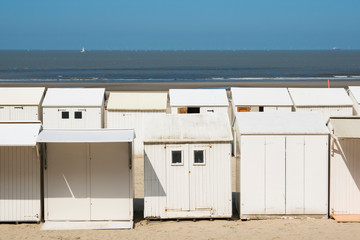 white beach houses, cabines in Blankenberg, Belgium, against blue sky