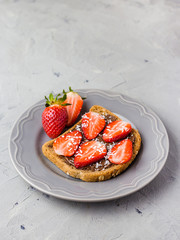 Toast with chocolate and strawberry, Single sandwich with chocolate cheese on white plate, top view