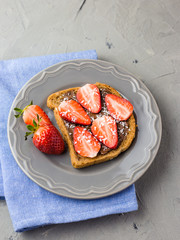 Toast with chocolate and strawberry, Single sandwich with chocolate cheese on white plate, top view