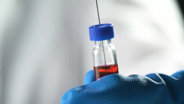 Close up of a needle drawing up the MMR vaccine from a vial to prevent measles, mumps, and rubella