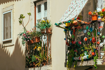 Fototapeta na wymiar Flowers Balcony On City Street In Lisbon, Portugal