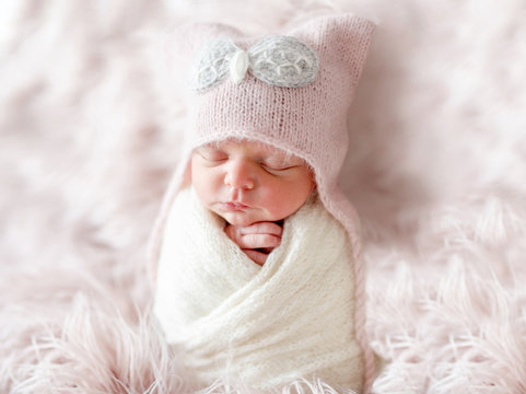 Newborn in beanie hat on a shaggy carpet