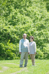 草原で微笑むシニア夫婦