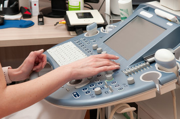 The hands of the doctor close up on the ultrasound machine