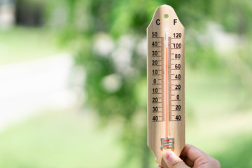 Close up hand holding thermometer with hot temperature