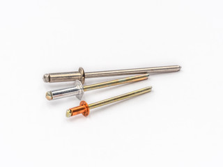 Mixed flat pop rivets with mixed mandrels on white.