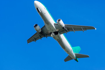 Fototapeta na wymiar Airplane in flight viewed from the ground, with a clear blue sky