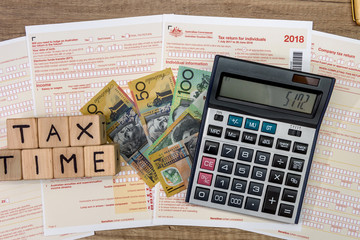 Australian dollar banknotes with wooden cubes at tax form